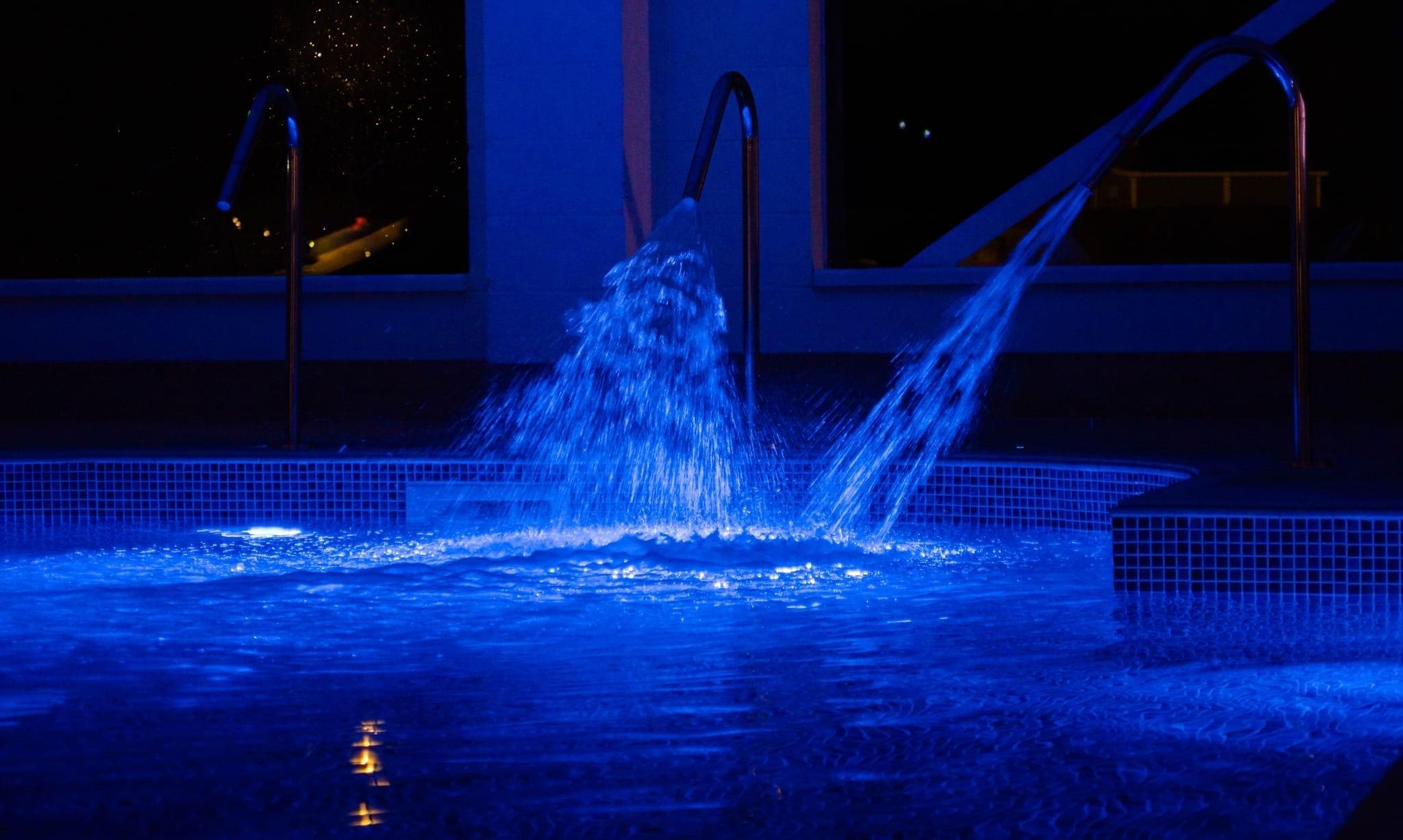 The image depicts a bright and modern indoor swimming pool with still turquoise water, surrounded by comfortable poolside loungers, creating a relaxing atmosphere in a local leisure centre. This inviting space is perfect for customers looking to unwind and enjoy their fitness journey in the East Riding area.